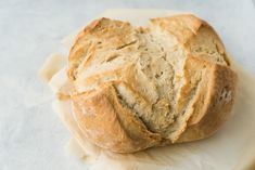 a loaf of bread sitting on top of a piece of wax paper next to a knife