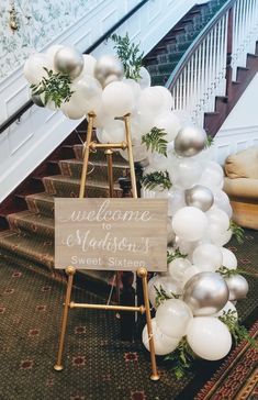 a welcome sign and balloon garland on the stairs at a wedding reception in washington, d c