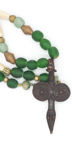 PEINTURE DE LOBI Tribal necklace with LOBI pendant,Bone Beads and green powder glas beads  . . . antique BONE beads,with carved pattern,about 45-50 years old, from Westafrica, various brass/messing beads from Westafrica ("lost form"), green KROBO beads (light - and dark green) made from powderglas, from Westafrica, 2 dark green beads made from antique glas, facet cut,from India, . . . a dream-beautiful pendant of the LOBI  (PROTECTION PENDANT) Total lenght incl. pendant : about 32.28 inch Pendan Traditional Green Necklace For Meditation, Spiritual Recycled Glass Beads For Gifts, Spiritual Beaded Jewelry With Recycled Glass, Handmade Green Amulet Beaded Necklace, Green Spiritual Beaded Necklace With Spacer Beads, Spiritual Green Beaded Necklace With Spacer Beads, Recycled Glass Jewelry With Spacer Beads As Gift, Recycled Glass Spacer Beads Jewelry As Gift, Traditional Green Spacer Beads