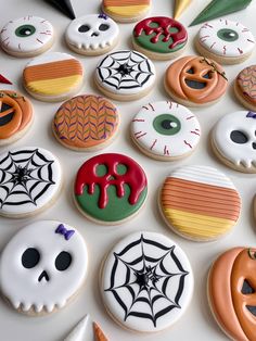 halloween decorated cookies are arranged on a white surface with spooky eyes and pumpkins