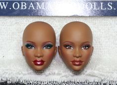 two doll heads are sitting on a towel