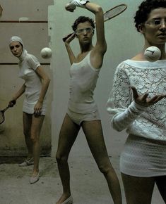 three women are holding tennis racquets and balls in their hands while wearing white clothing