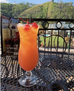 an orange drink sitting on top of a metal table