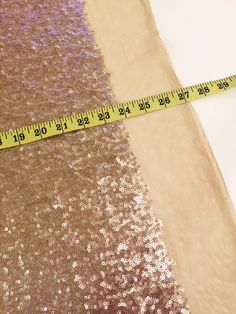 a measuring tape is on top of sequin fabric