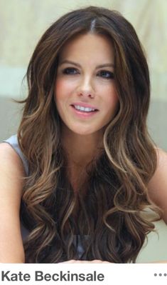 a woman with long brown hair sitting at a table