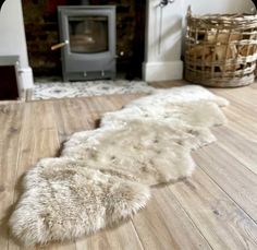 two sheepskin rugs are laying on the floor in front of a fire place