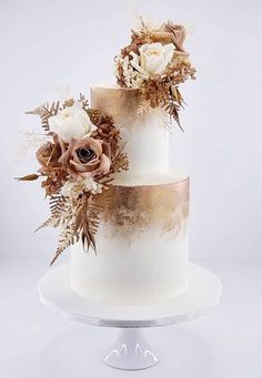 a three tiered white cake with flowers on top