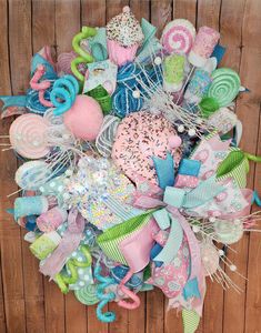 a wreath made out of fabric and ribbons on a wooden fence with the word love spelled in