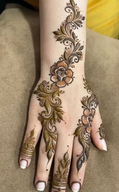 a woman's hand with henna tattoos on it