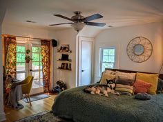 a dog laying on top of a green bed in a bedroom next to a window