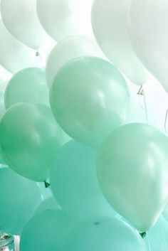 green and white balloons floating in the air