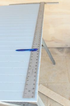 a ruler with a blue pen on top of it next to a piece of wood