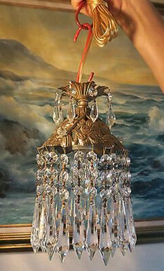 a chandelier hanging from the ceiling in front of a painting