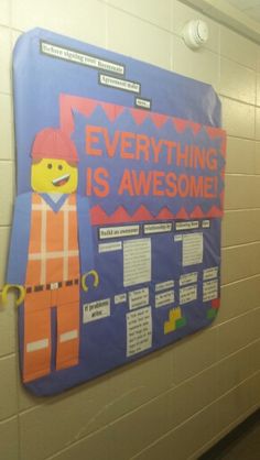 a bulletin board on the wall in a school hallway that says everything is awesome and there are legos attached to it