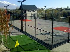 an outdoor basketball court surrounded by grass and lights