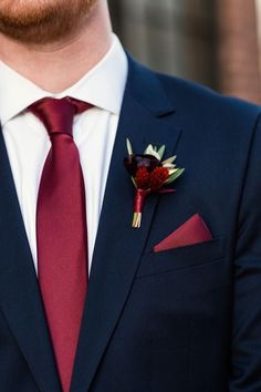 a man in a suit and tie with a boutonniere on his lapel