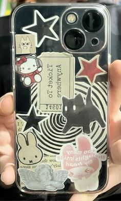 someone holding up their phone case with stickers on it