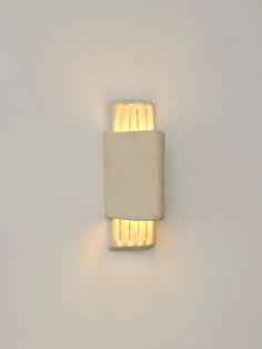 a white wall light with two lights on it's side and one is lit up