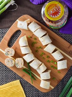 sliced up food on a cutting board next to green onions and other items for making sushi