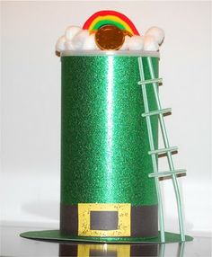 a green hat with white balls and a rainbow on top