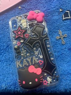 a hello kitty phone case sitting on top of a blue towel next to other items