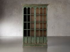 an old green bookcase sitting on top of a cement floor