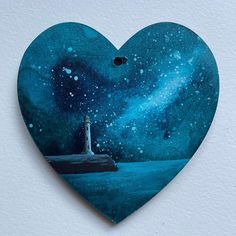 a heart shaped painting with a lighthouse on it