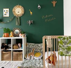 a baby's room decorated in green and white with animals on the wall, crib