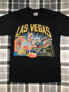 a black las vegas t - shirt sitting on top of a bed