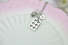 "This is a silver-tone baking pan and cupcake charm with hand stamped initial charm on a chain. You able to choose initial charm from a drop-down menu. You able to choose as a necklace, bracelet chain, bangle or key chain. ♥ You will receive 1 necklace ♥ Charm zinc metal alloy baking pan 22 x 13 mm., cupcake 14x10mm. ♥ Initial charm stainless steel 10mm, choose from a drop-down menu. ♥ Keyring 30mm or Necklace approx. 18 inches (either stainless steel or brass) or Bracelet chain 6 1/2 with 2 inc Silver Stamped Charm Necklace For Birthday, Silver Hypoallergenic Charm Necklace For Birthday, Nickel-free Silver Charm Necklace For Birthday, Cupcake Necklace, Cupcake Charms, Silver Keychain, Nana Gifts, Bracelet Chain, Baking Pan