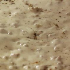 a bowl filled with white sauce on top of a table