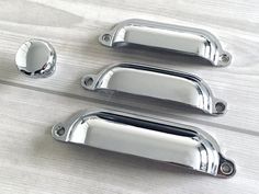 four chrome door handles on a wooden surface