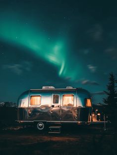 an rv is parked under the aurora bore