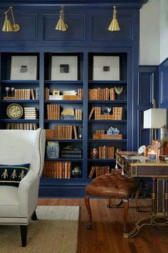 a living room with blue bookcases and leather chair in front of the bookshelf