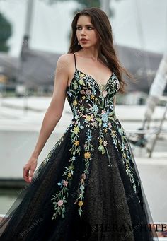 a woman in a black dress standing on a dock