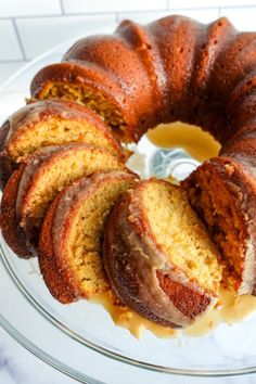 a bundt cake with slices cut out and sitting on a glass platter,