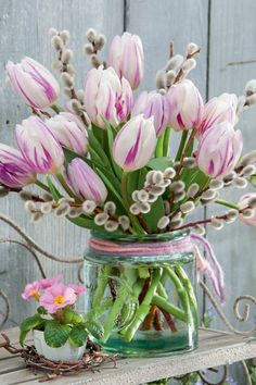 a glass jar filled with pink and white flowers