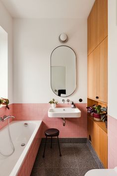 a bathroom with pink tiles and white fixtures