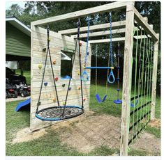 a wooden play structure with swings and climbing ropes