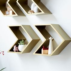 three shelving units are arranged on the wall to display decorative items and other things