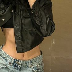 a woman wearing a black leather jacket and jeans