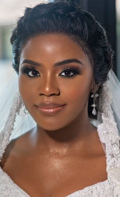 a woman in a wedding dress posing for the camera with her veil pulled back over her head