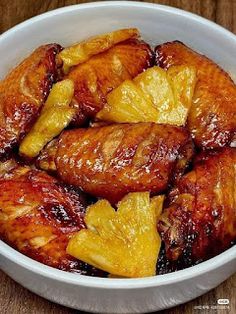 a white bowl filled with pineapple chicken wings