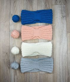 three crocheted headbands and two balls of yarn are laid out on the floor