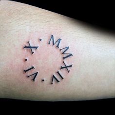 a tattoo with roman numerals on the arm and an arrow in the middle