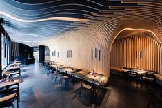 the interior of a restaurant with curved wooden walls