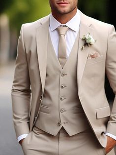 a man wearing a tan suit and white shirt with a flower in his lapel