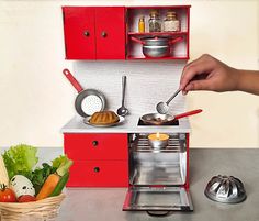 a person is cooking food in a toy kitchen