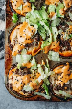 an overhead view of some tasty looking food on a baking sheet with lettuce and sauce