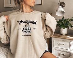 Disneyland California Sweatshirt,Retro Mickey And Friends Disneyland Est 1955 Sweater,Disneyland Shirt,Family Vacation Shirt,Disneyland TEE We design trendy sweatshirts that you can use in every important day of your life. We produce beautiful and quality designs that can be used in all kinds of activities that you will do with your family or friends. These designs will offer you and your environment a unique complement. We are very excited to bring you our high quality and soft, trendy sweatshi Disney Christmas Gifts, Ballerina Silhouette, Outlander Book Series, Designed Shirts, V Neck Shirts, Elizabeth Bennet, Outlander Book, Funny Mom Gifts, Jamie Fraser